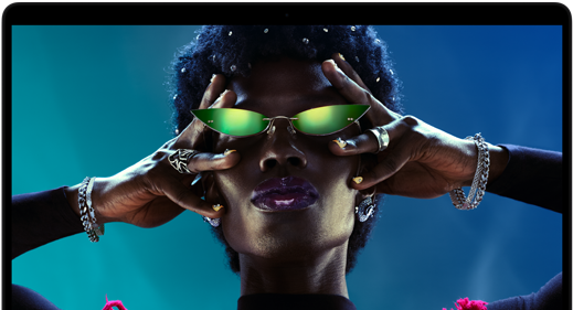 Colourful screen on a MacBook Pro of a person crowdsurfing at a party, showcasing the vibrant Liquid Retina XDR display